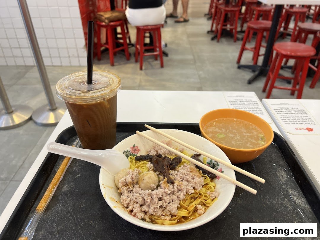 A delicious bowl of Teochew fishball noodles with minced meat, mushrooms, soup, and iced coffee.