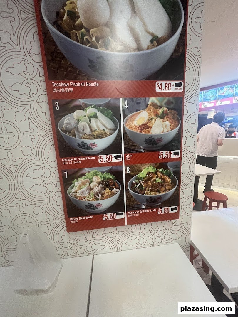 A vibrant menu board displaying various noodle dishes with prices and images.