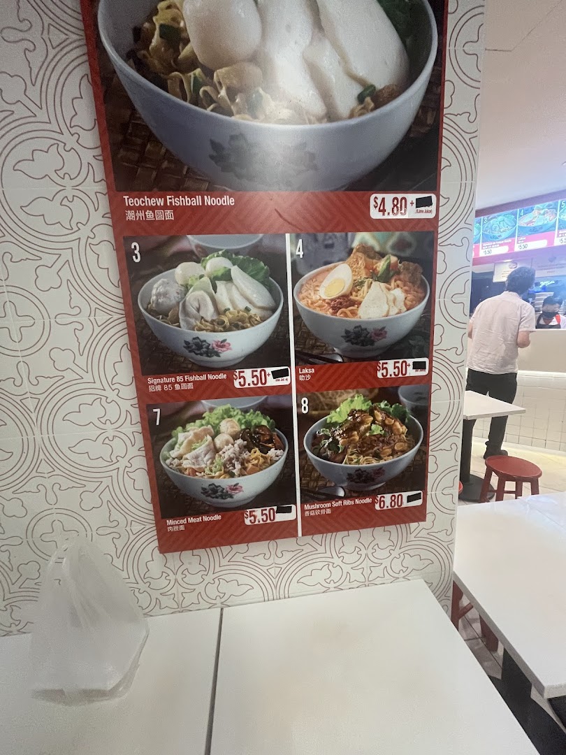 A vibrant menu board displaying various noodle dishes with prices and images.
