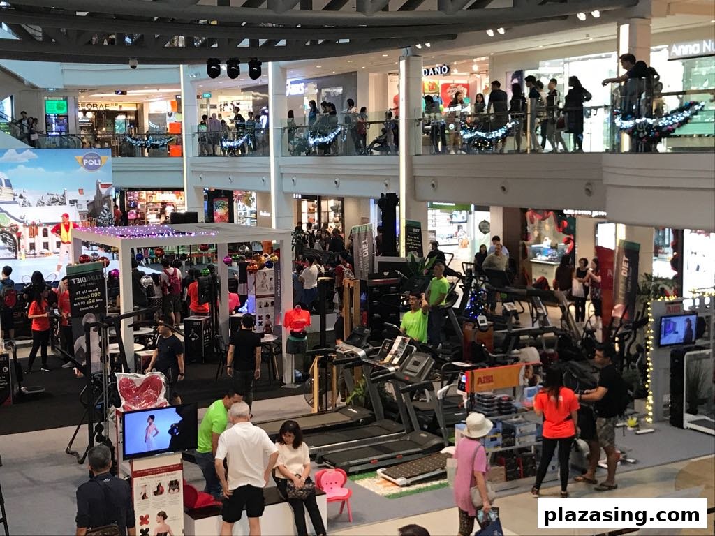 Busy mall interior showcasing Aibi's extensive fitness equipment display with many shoppers browsing.