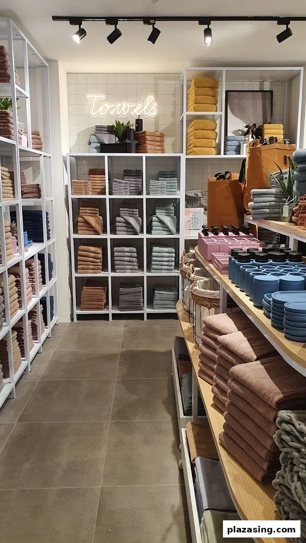 Interior view of AKEMI, showcasing neatly folded towels and bath accessories on modern display shelves.