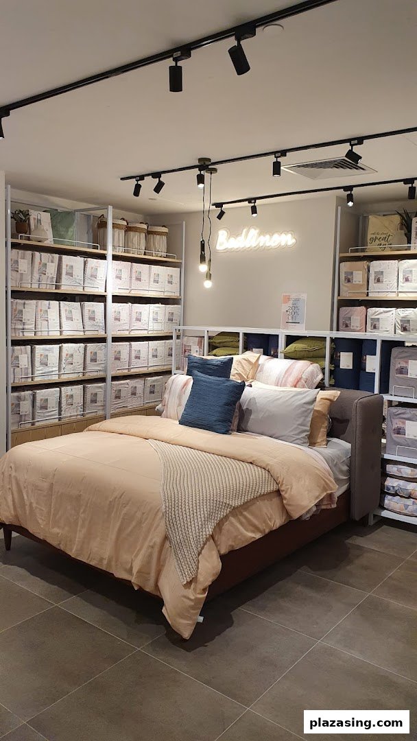 An inviting bed display showcasing various bedding sets and home textiles in a retail store.