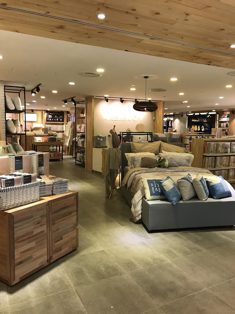 Interior view of AKEMI home textile store, showcasing bedding and home decor displays.
