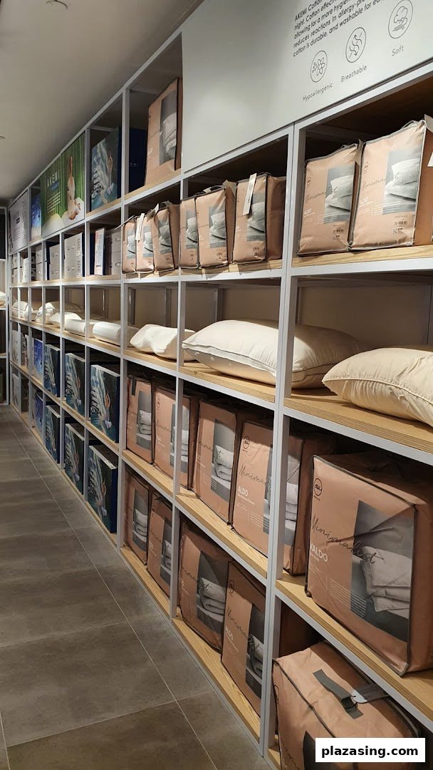 Shelves filled with packaged bedding, pillows, and home linen products inside the AKEMI store.