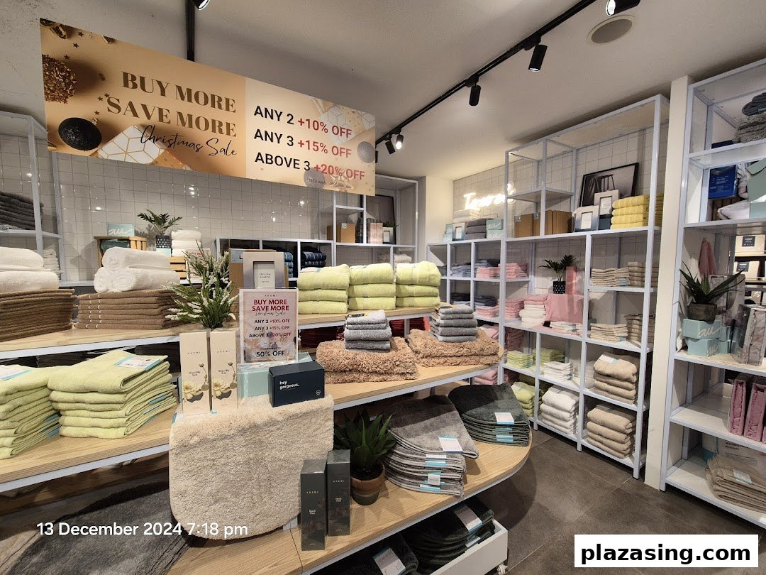 Interior view of AKEMI store showcasing neatly folded towels and home textiles with a Christmas sale banner.