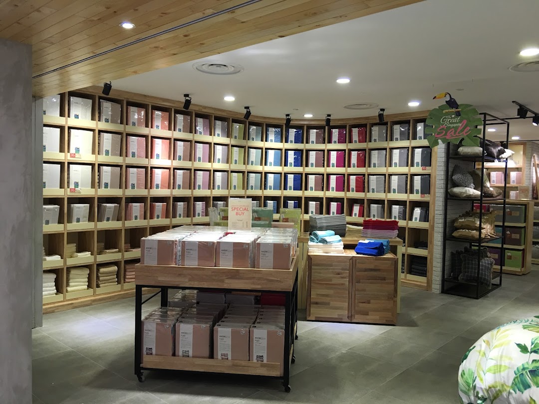 Interior view of AKEMI store showcasing a wide array of neatly displayed bedding and home linen products.