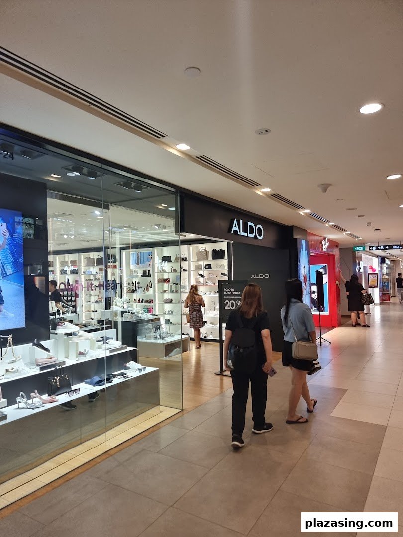 The ALDO shop front in a mall, showcasing shoes and accessories, with shoppers passing by.