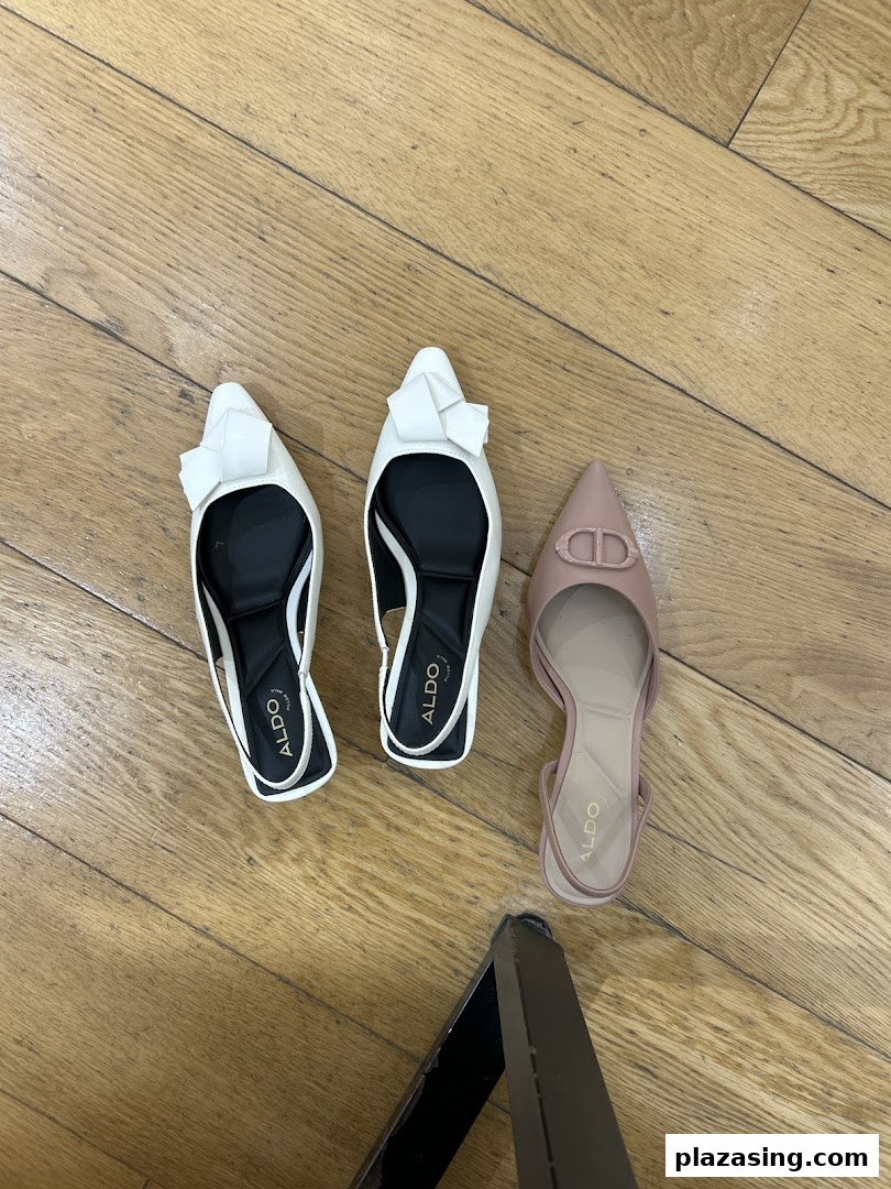 Three pairs of stylish ALDO shoes, two white and one nude, displayed on a wooden floor.