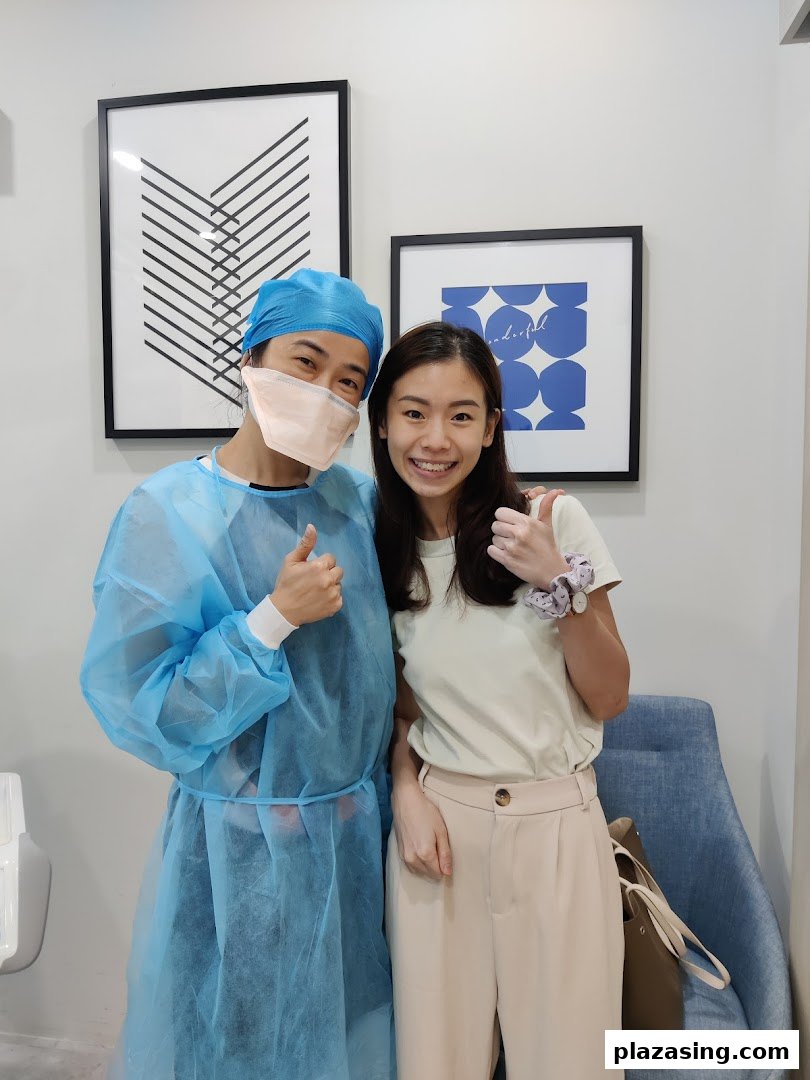 A dental professional and a happy patient giving thumbs up in a clinic setting.