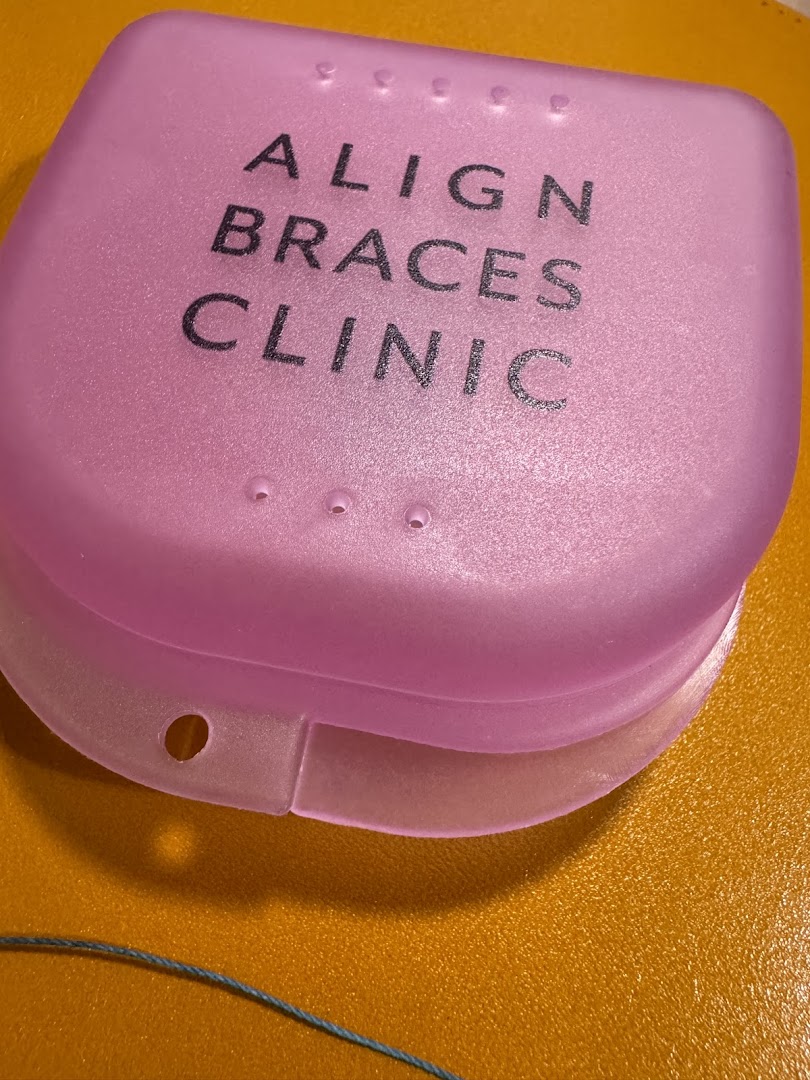 A pink case with 'ALIGN BRACES CLINIC' text, likely for dental retainers or aligners.