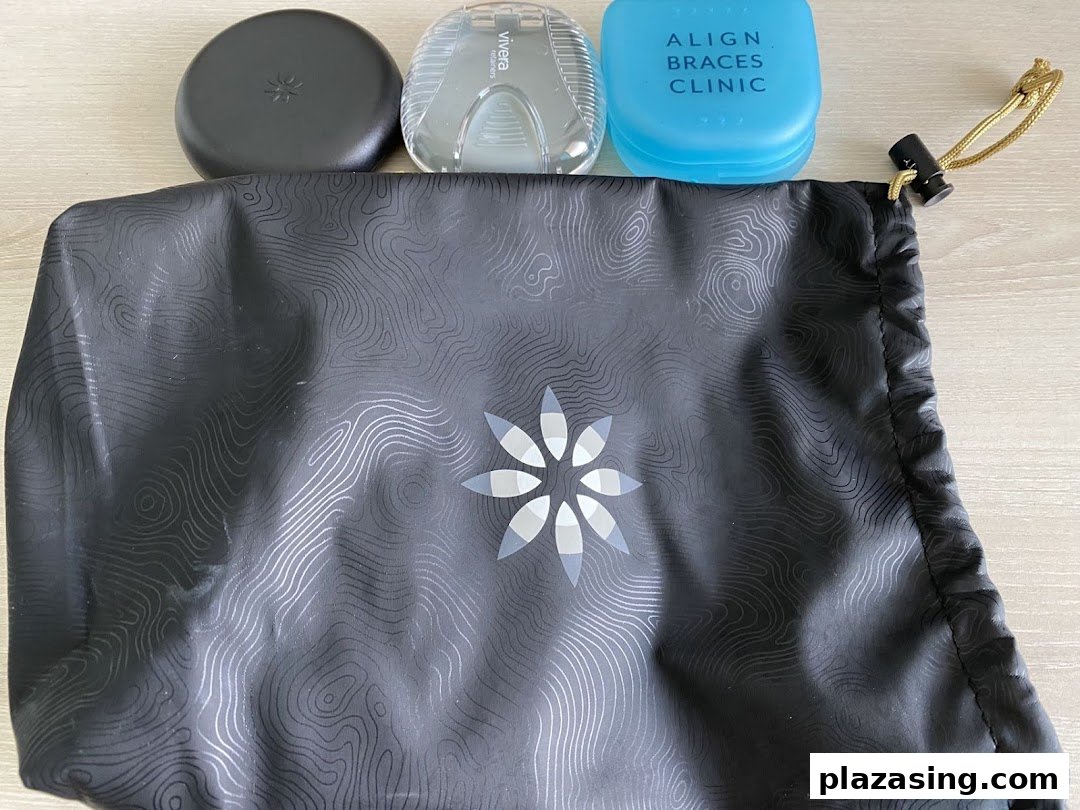 A black drawstring bag with dental aligner cases, including one labeled 'Align Braces Clinic'.