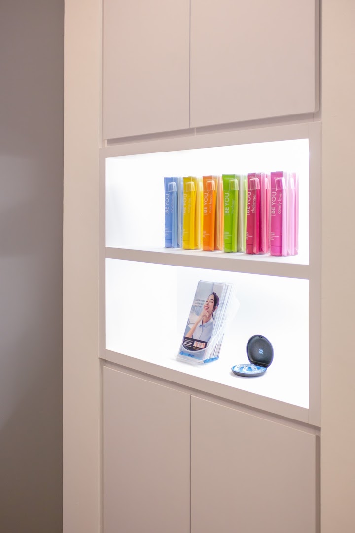 Illuminated display shelves showcasing colorful dental care products and informational brochures.