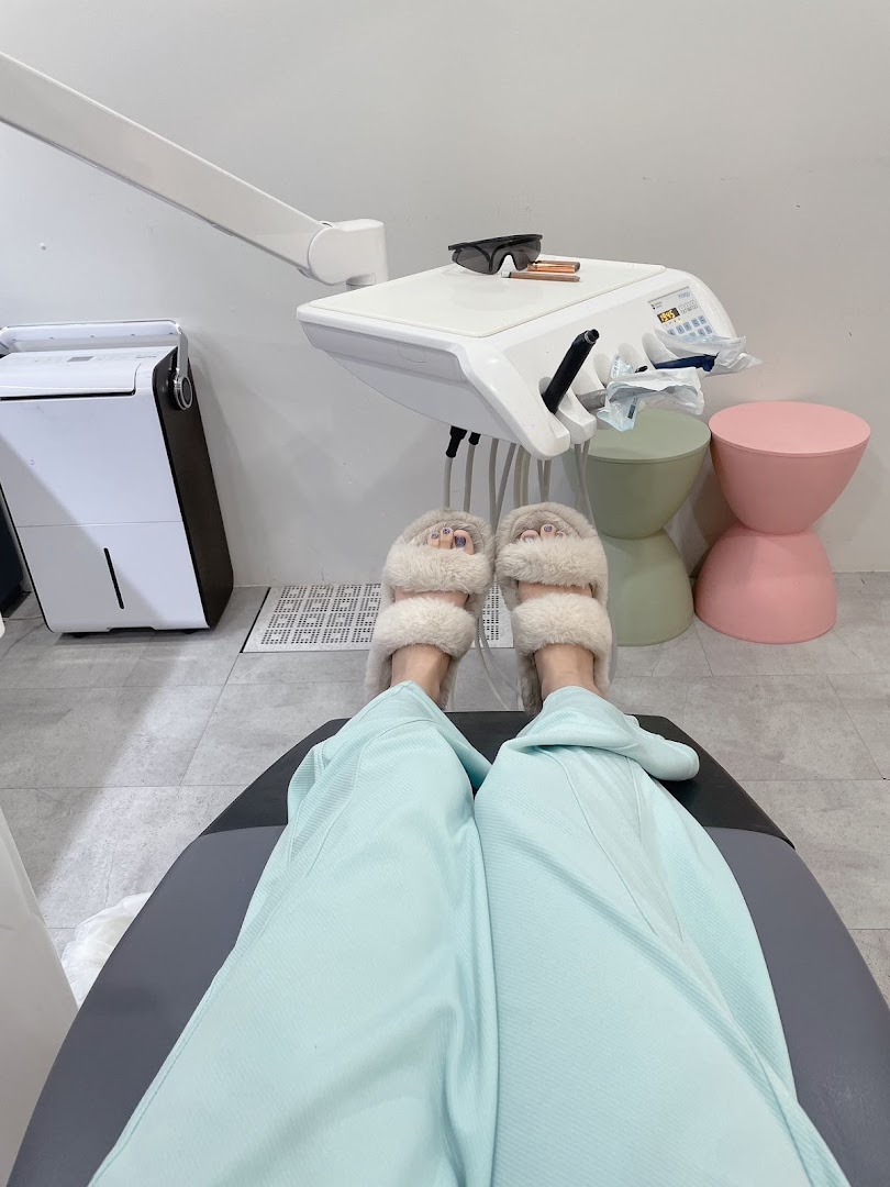 A patient's view from a dental chair, showing comfortable slippers and modern clinic equipment.