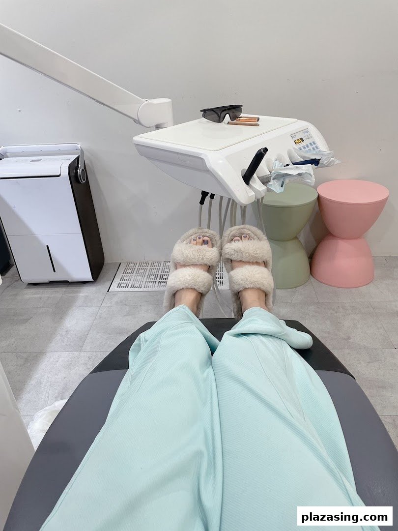 A patient's view from a dental chair, showing comfortable slippers and modern clinic equipment.