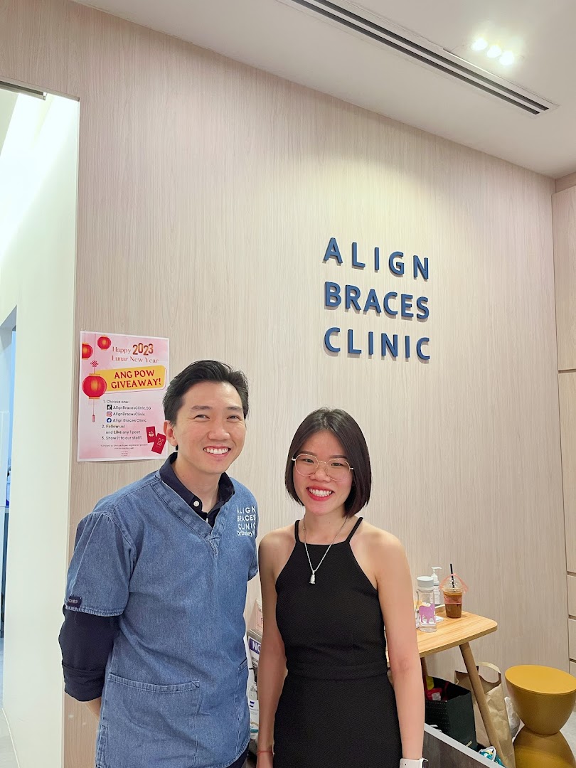 Two smiling individuals stand inside Align Braces Clinic, featuring the clinic's branding.