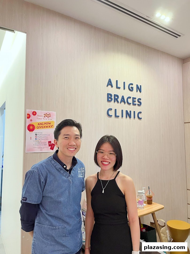 Two smiling individuals stand inside Align Braces Clinic, featuring the clinic's branding.