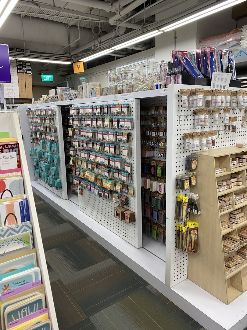 An interior view of Art Friend, showcasing aisles filled with diverse art and craft supplies, including stamps and embellishments.