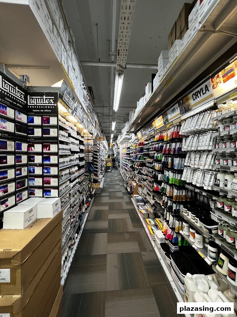 A long aisle inside Art Friend, showcasing a wide array of art supplies like paints and mediums on well-stocked shelves.