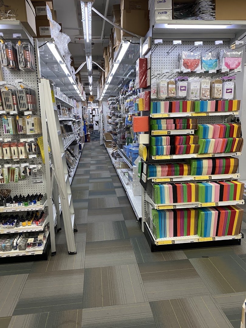 A long aisle inside an art supply store, showcasing a wide array of colorful art and craft materials.