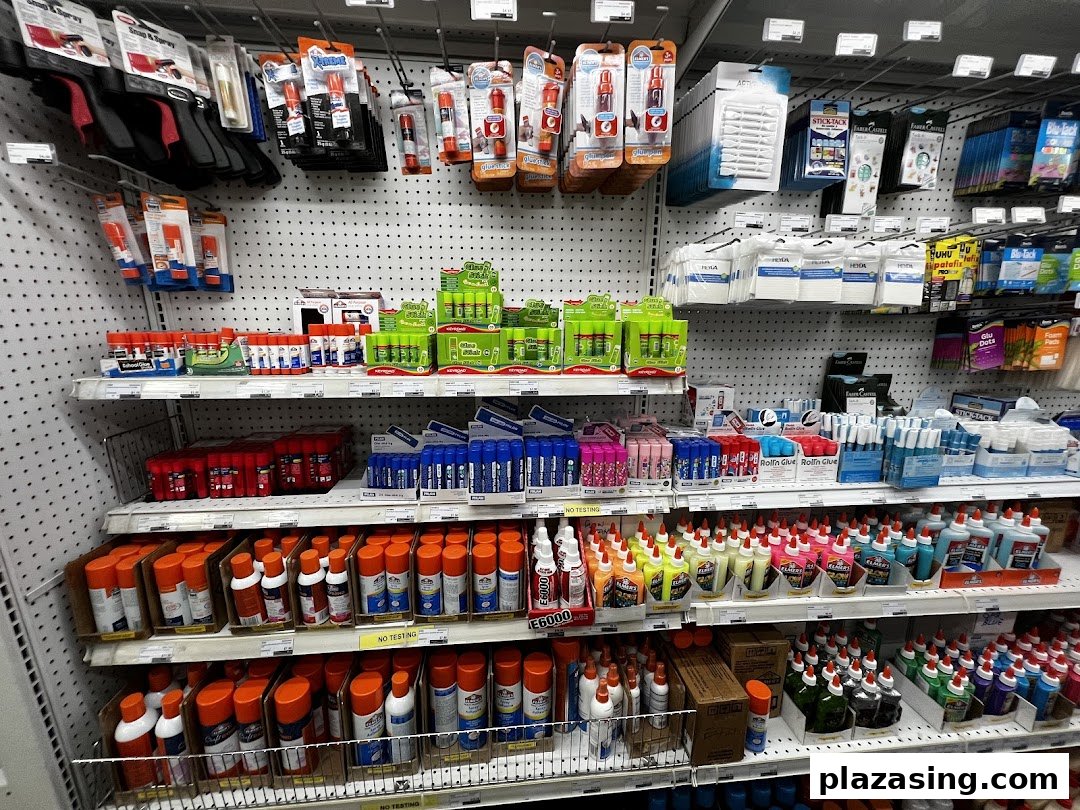 Shelves at Art Friend displaying a wide variety of glues, adhesives, and craft supplies.