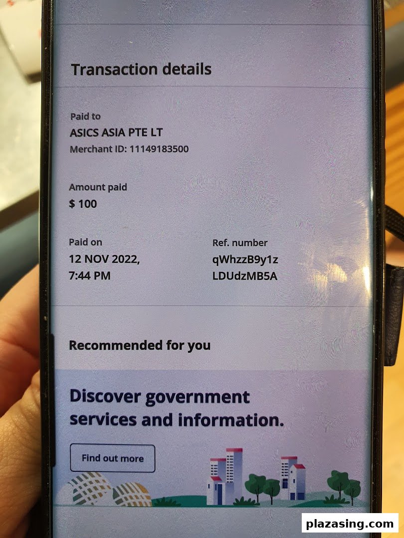 A phone screen displaying transaction details for a $100 payment made to ASICS ASIA PTE LT.