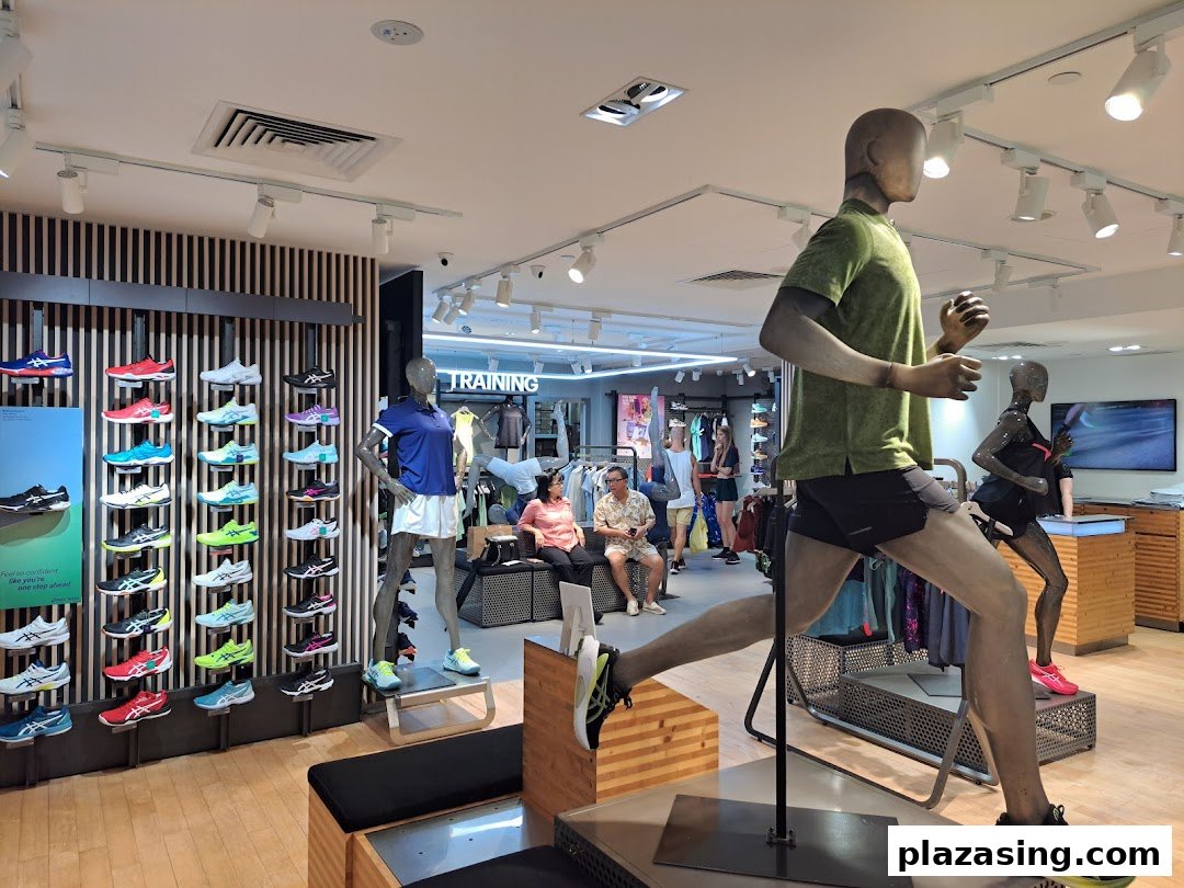 Interior view of an ASICS store showcasing running shoes on display and athletic mannequins.