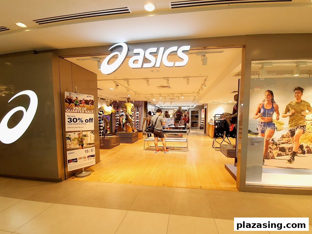 The ASICS store entrance features its prominent logo, display windows, and a glimpse of the interior.