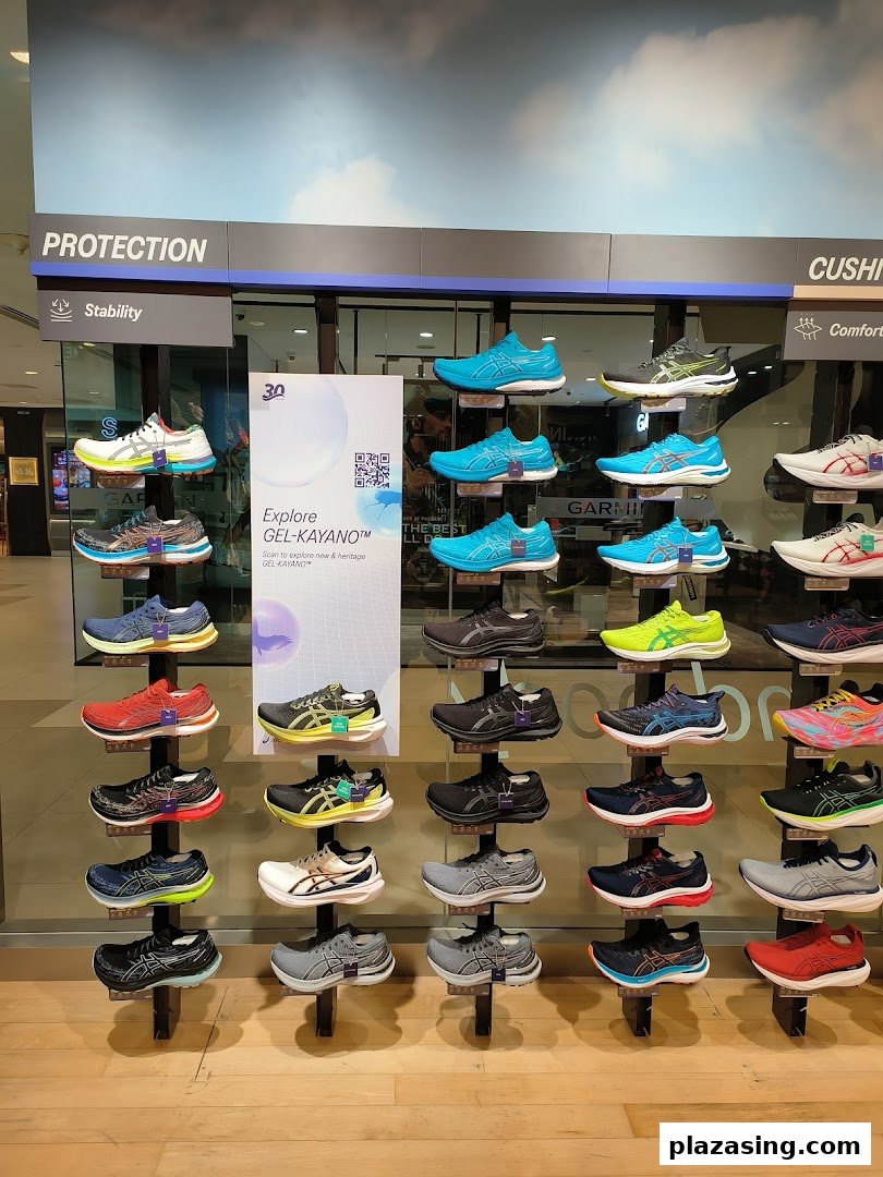 A vibrant display of ASICS running shoes showcasing various models and colors in a retail store.
