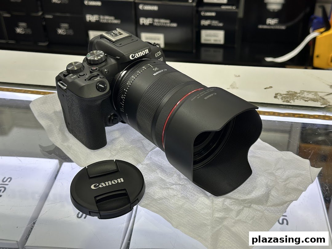 A Canon EOS R10 camera with an RF 35mm lens displayed in a photo electronics shop.