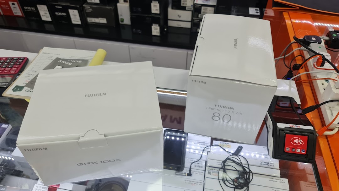 Fujifilm camera and lens boxes displayed on a counter at Bally Photo Electronics.