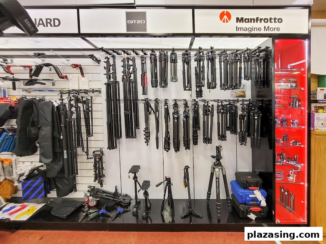 A retail display showcasing a wide selection of camera tripods and photography accessories.