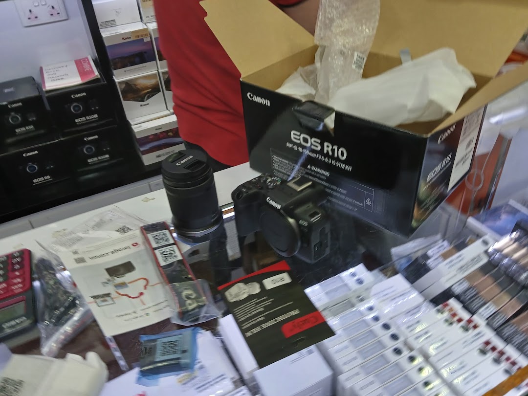 A display of Canon cameras, lenses, and electronics in a retail shop.