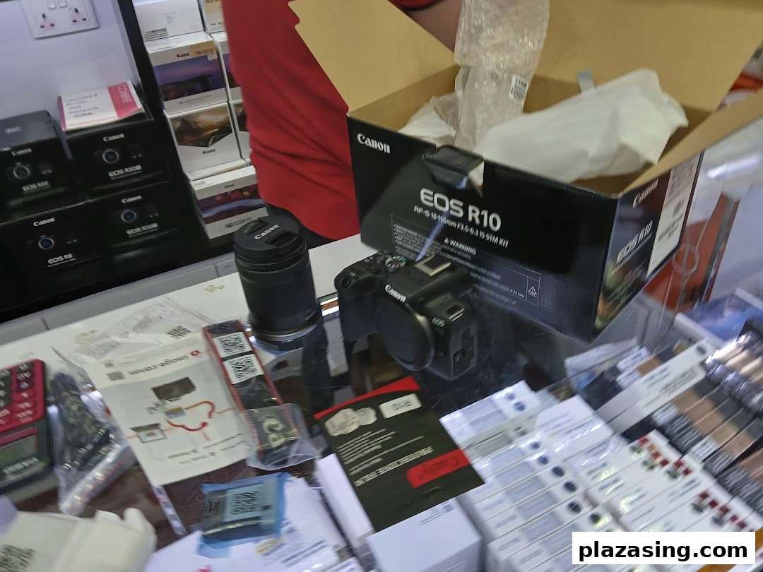 A display of Canon cameras, lenses, and electronics in a retail shop.