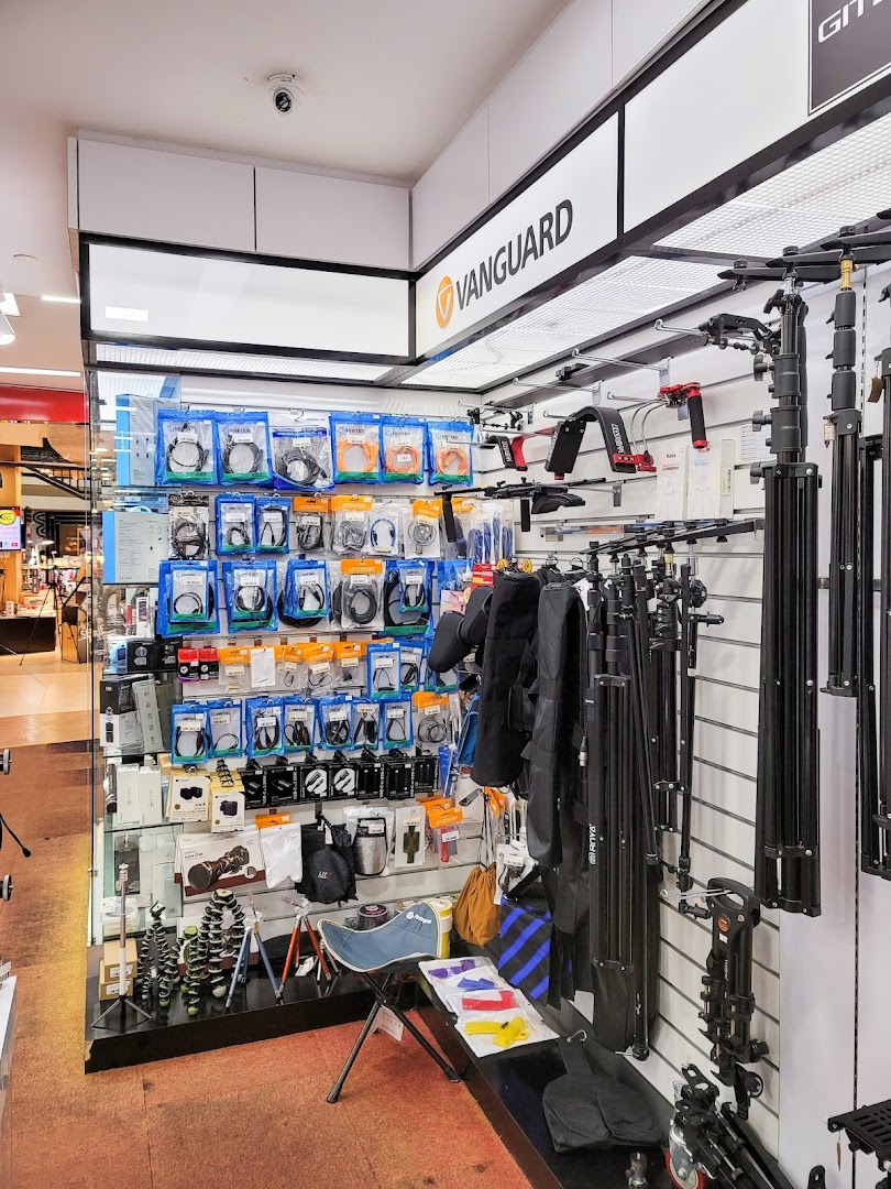 An interior view of Bally Photo Electronics, showcasing camera accessories, tripods, and various electronic gadgets.