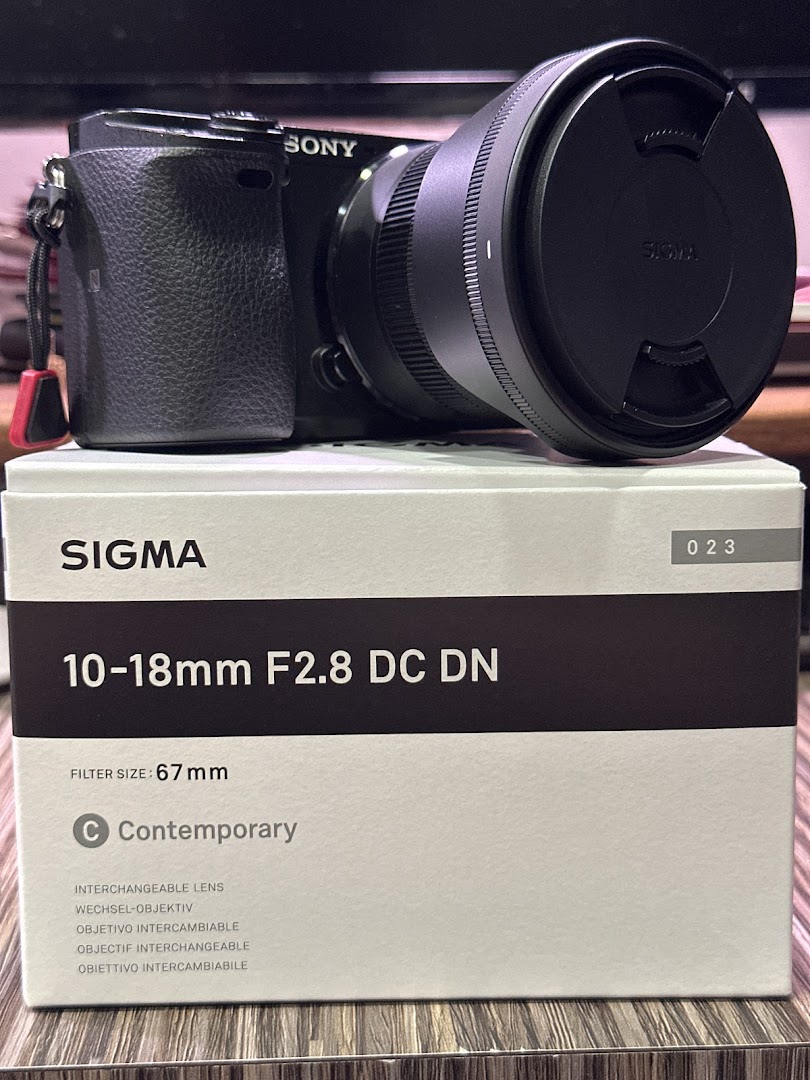 A Sony camera with a Sigma lens and its product box, showcasing photography equipment.