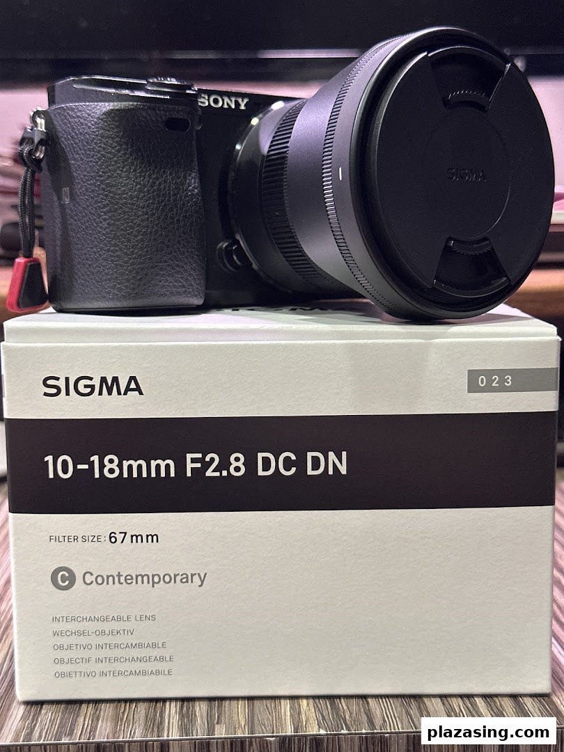 A Sony camera with a Sigma lens and its product box, showcasing photography equipment.