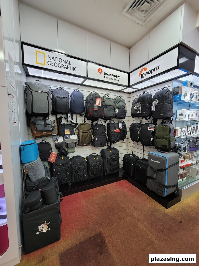 A retail display showcasing various camera bags and backpacks from top brands like National Geographic and Manfrotto.