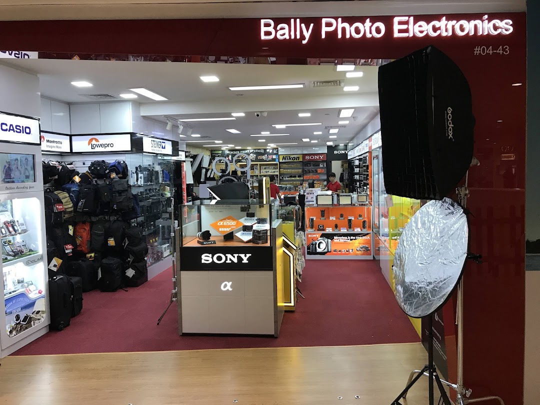 Entrance of Bally Photo Electronics, showcasing cameras, electronics, and photography accessories like bags and lighting.