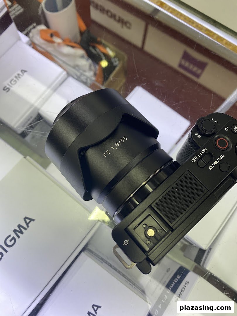 A close-up of a camera with a lens on display, surrounded by Sigma product boxes.