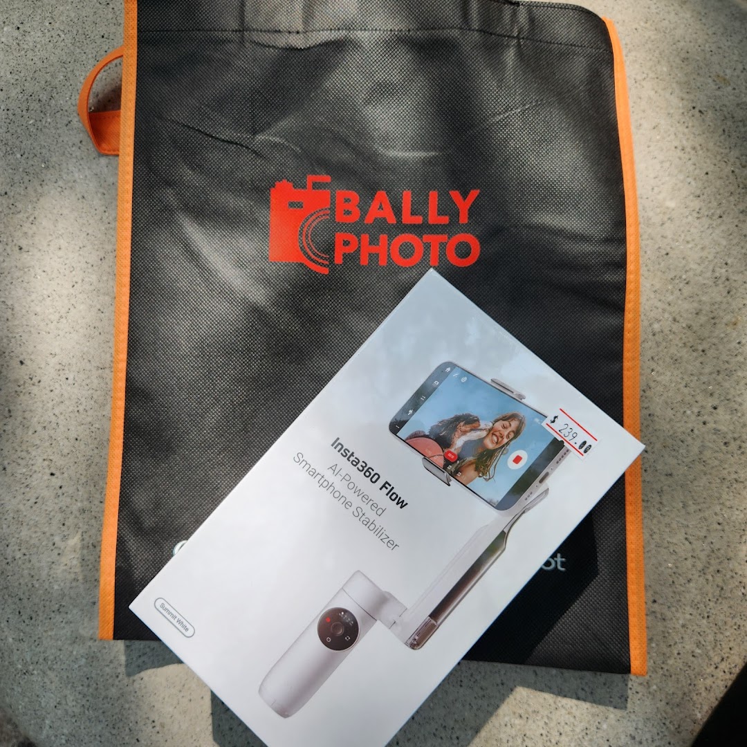 An Insta360 Flow smartphone stabilizer box and a Bally Photo shopping bag on a textured surface.