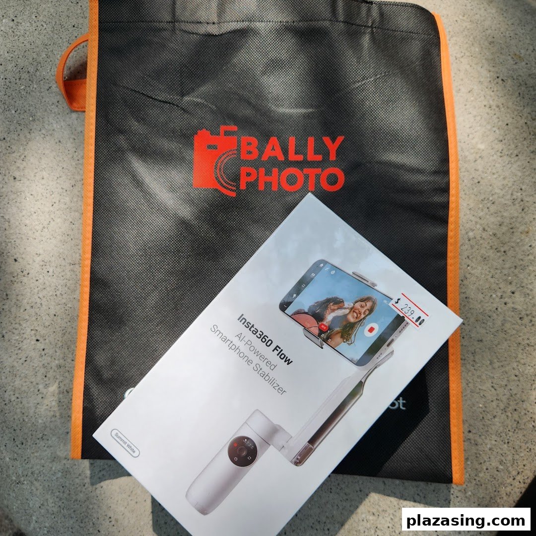 An Insta360 Flow smartphone stabilizer box and a Bally Photo shopping bag on a textured surface.
