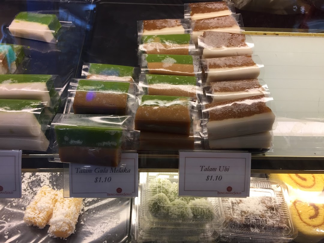 A vibrant display of traditional Indonesian and Peranakan kueh, including Talam Gula Melaka and Talam Ubi.