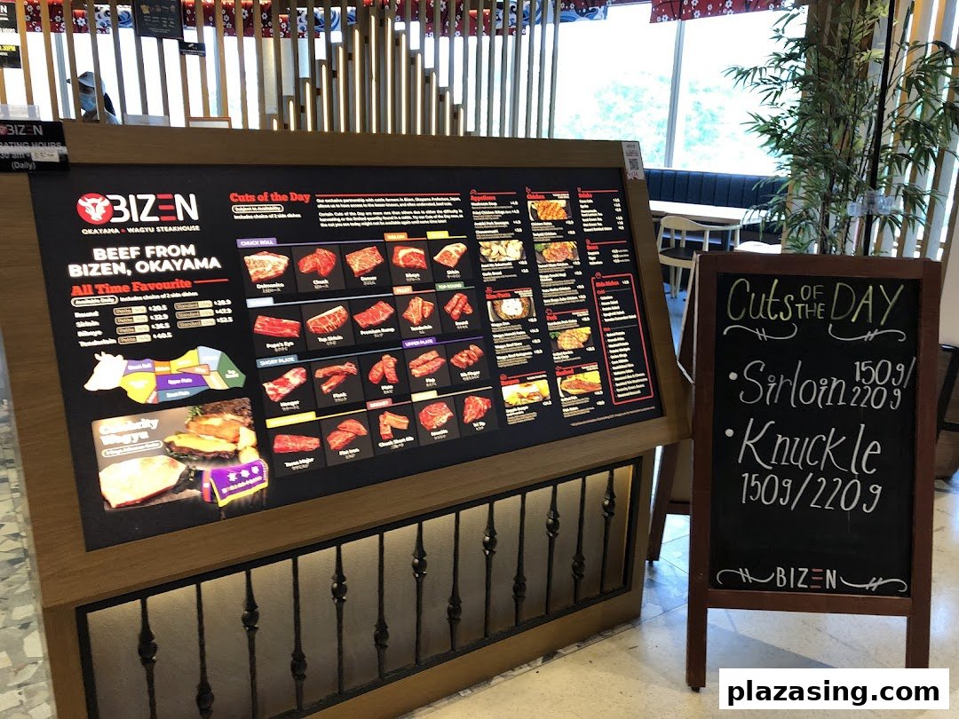 A large digital menu board showcasing wagyu beef cuts and prices, accompanied by a chalkboard with daily specials.