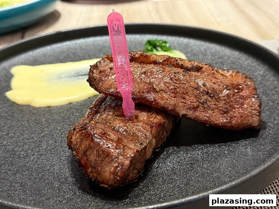 A perfectly cooked steak served on a dark plate with a side of mashed potatoes and a pink pick.