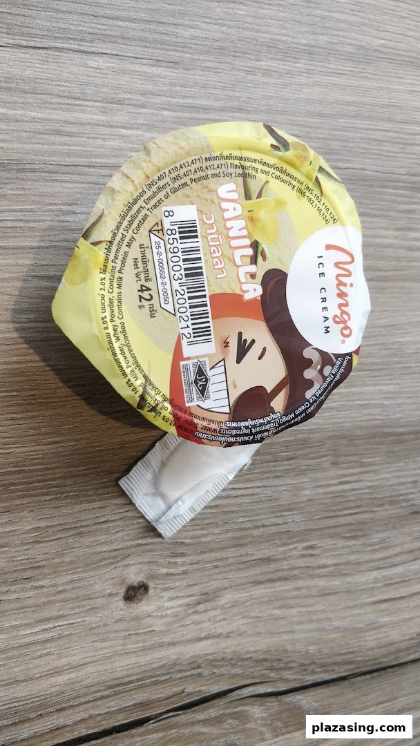 A Mingo vanilla ice cream cup with a small spoon, resting on a wooden surface.