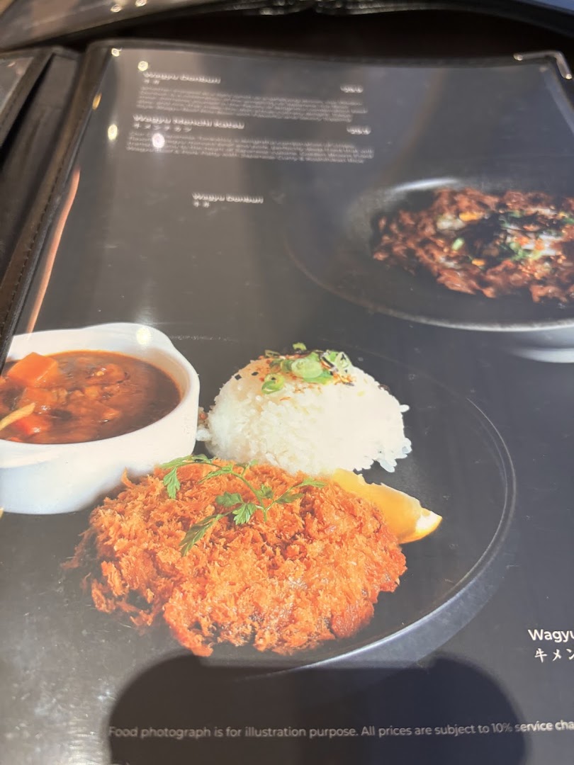 A menu page displaying a crispy breaded cutlet with rice and curry, alongside other Wagyu dishes.