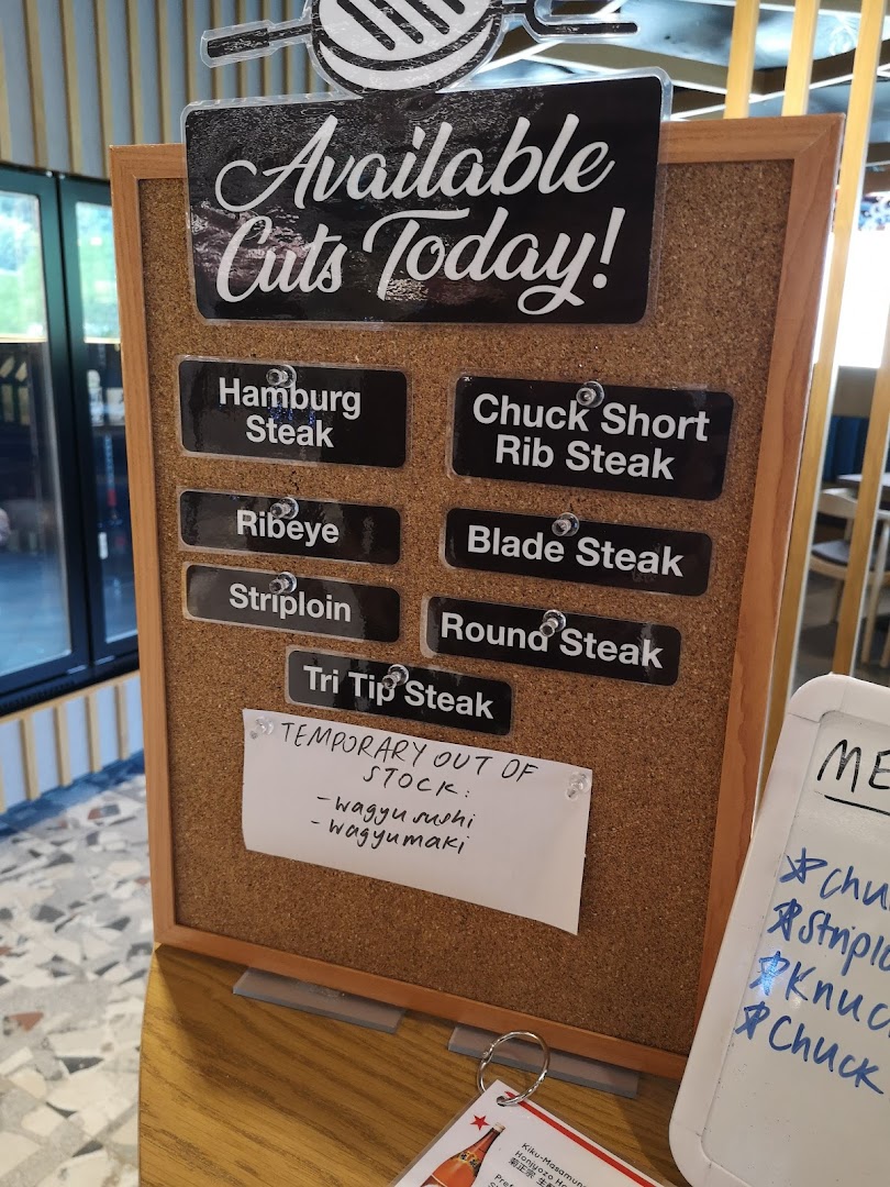 A corkboard display showcasing the available wagyu steak cuts for the day at Bizen Wagyu Salad Bar.