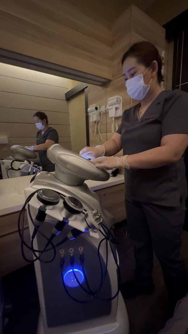 A staff member in a mask and gloves operates advanced body treatment equipment at BodyWerkz.