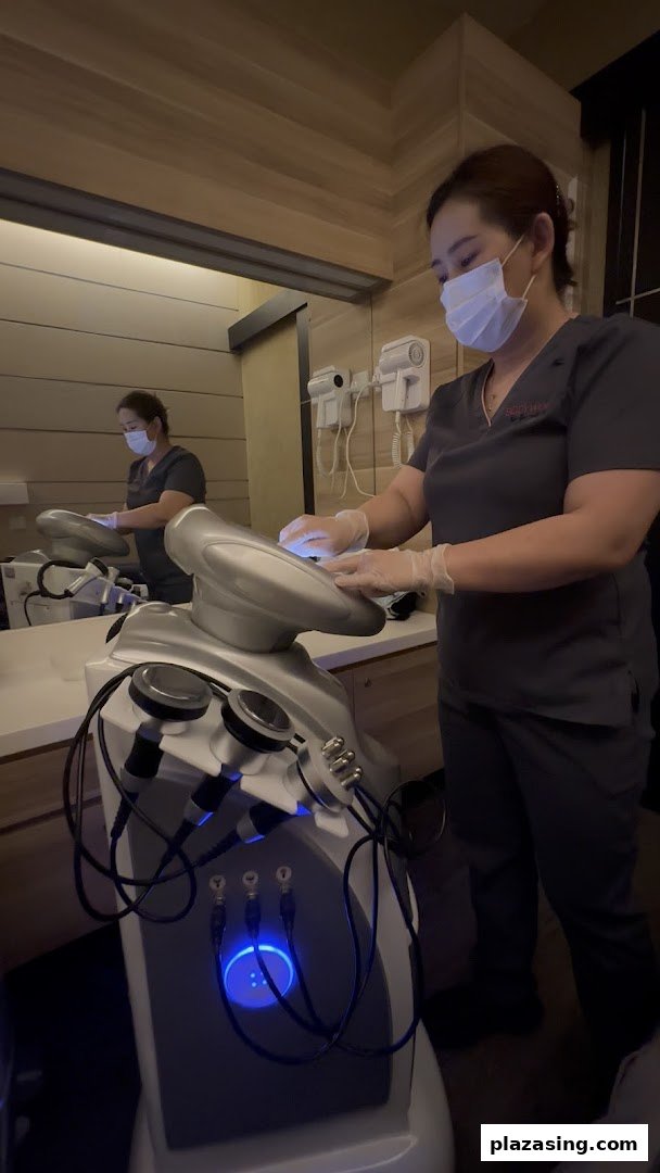 A staff member in a mask and gloves operates advanced body treatment equipment at BodyWerkz.