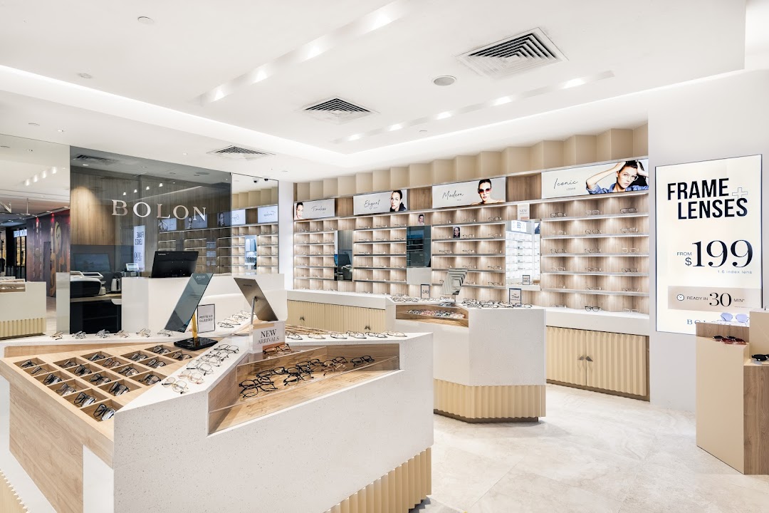 A bright and modern eyewear store interior showcasing various glasses and sunglasses displays.